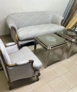 A light-colored, upholstered classic living room set featuring a sofa and armchairs with carved wooden frames, along with two matching mirrored side tables. - Image 5