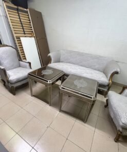 A light-colored, upholstered classic living room set featuring a sofa and armchairs with carved wooden frames, along with two matching mirrored side tables. - Image 7
