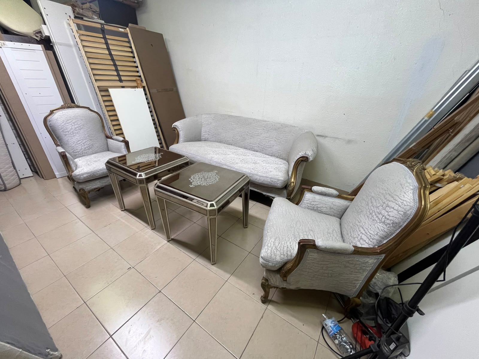 A light-colored, upholstered classic living room set featuring a sofa and armchairs with carved wooden frames, along with two matching mirrored side tables. - Image 10