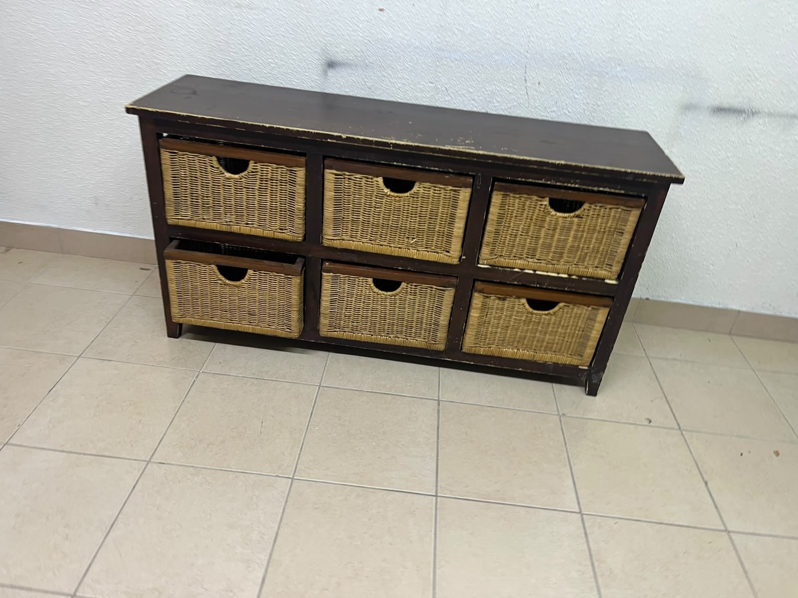 A dark brown wooden storage unit featuring six drawers in the form of woven bamboo baskets.