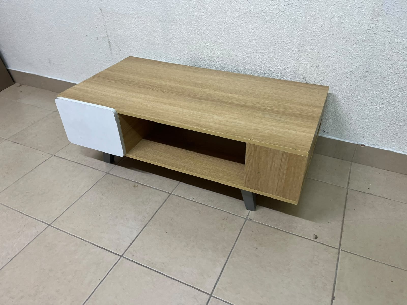 The Adonia coffee table by Danube Home is crafted from oak wood and features a rectangular top with a wood finish, accented by a distinctive white cabinet door. - Image 2