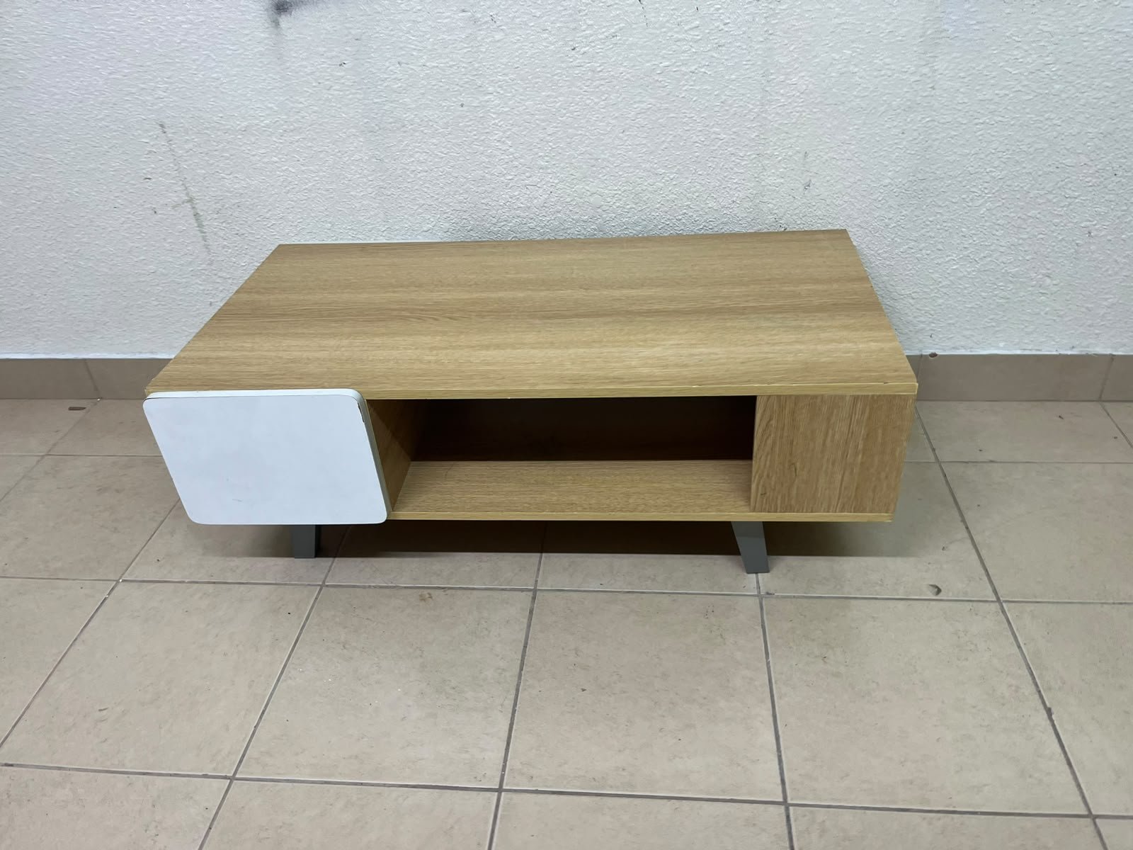 The Adonia coffee table by Danube Home is crafted from oak wood and features a rectangular top with a wood finish, accented by a distinctive white cabinet door.