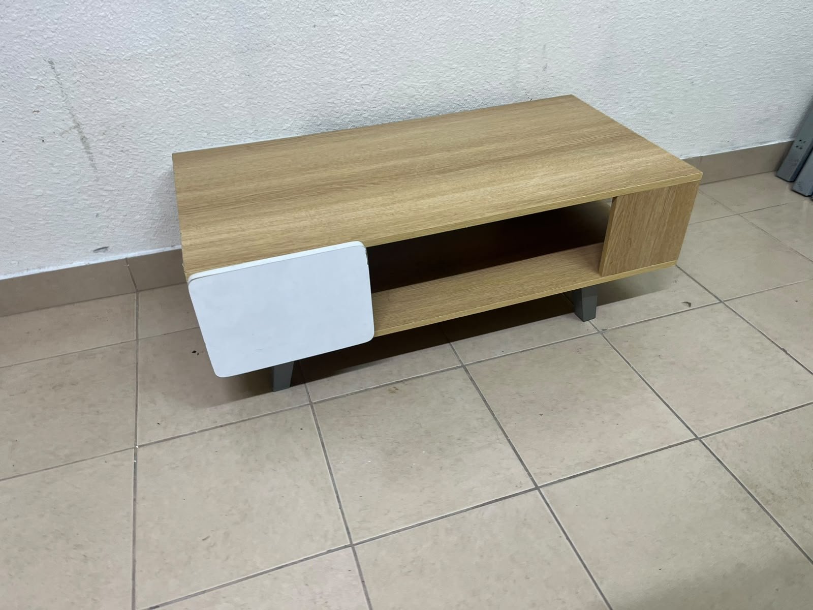 The Adonia coffee table by Danube Home is crafted from oak wood and features a rectangular top with a wood finish, accented by a distinctive white cabinet door. - Image 4