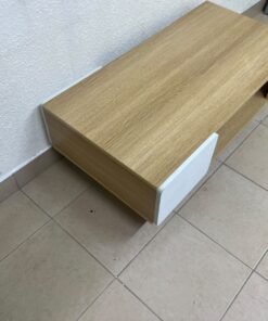 The Adonia coffee table by Danube Home is crafted from oak wood and features a rectangular top with a wood finish, accented by a distinctive white cabinet door. - Image 5