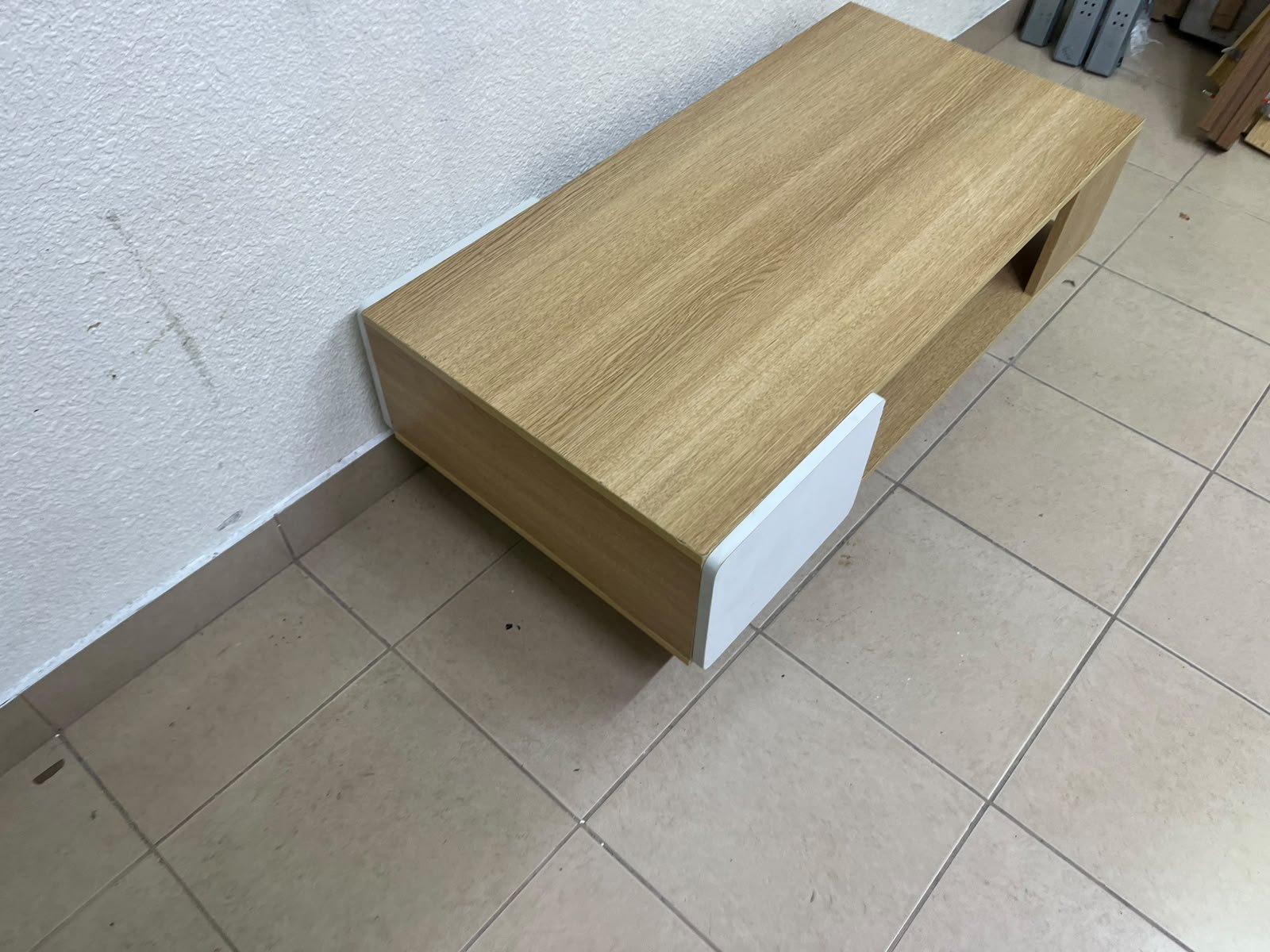 The Adonia coffee table by Danube Home is crafted from oak wood and features a rectangular top with a wood finish, accented by a distinctive white cabinet door. - Image 5
