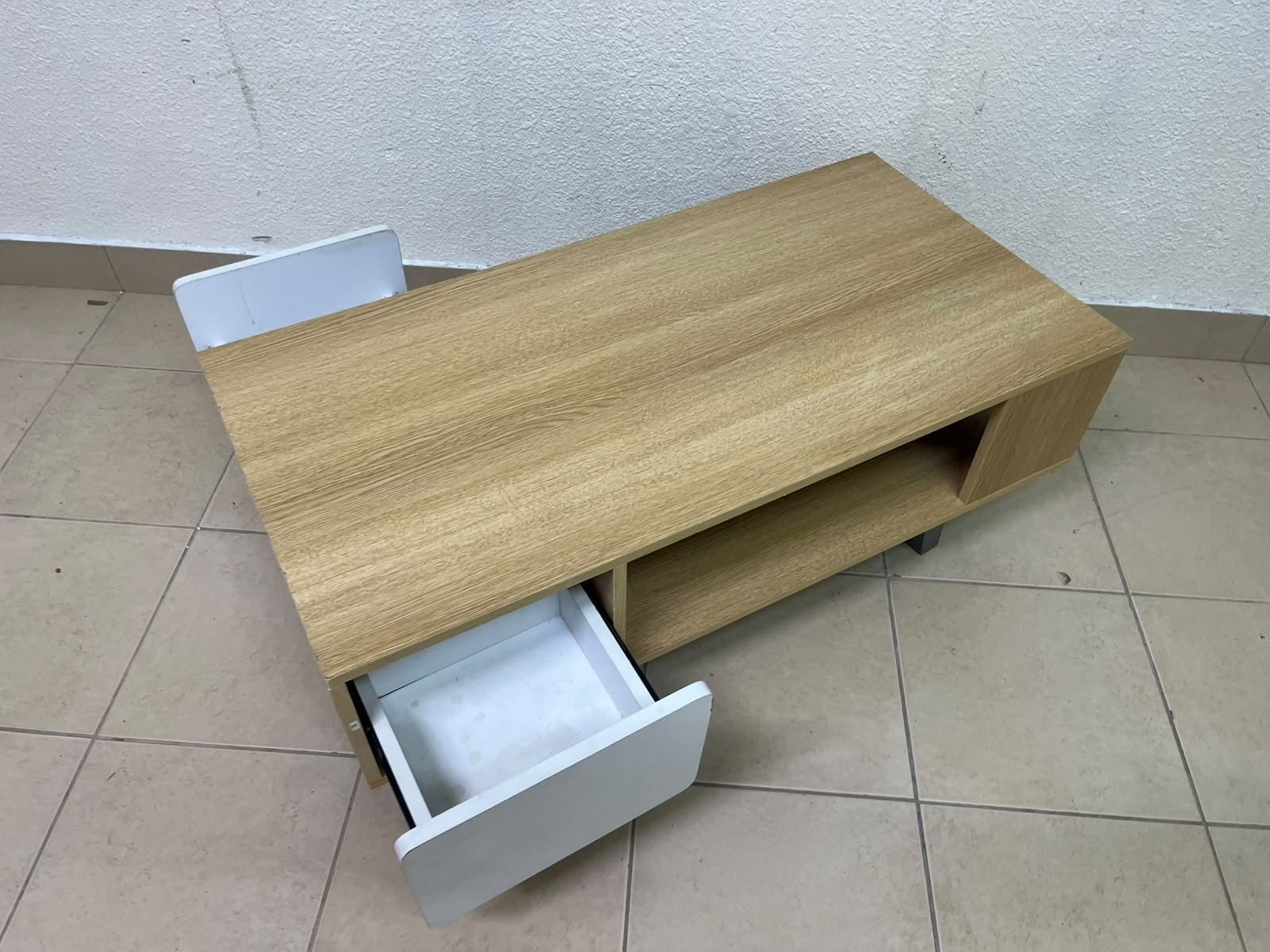 The Adonia coffee table by Danube Home is crafted from oak wood and features a rectangular top with a wood finish, accented by a distinctive white cabinet door. - Image 6