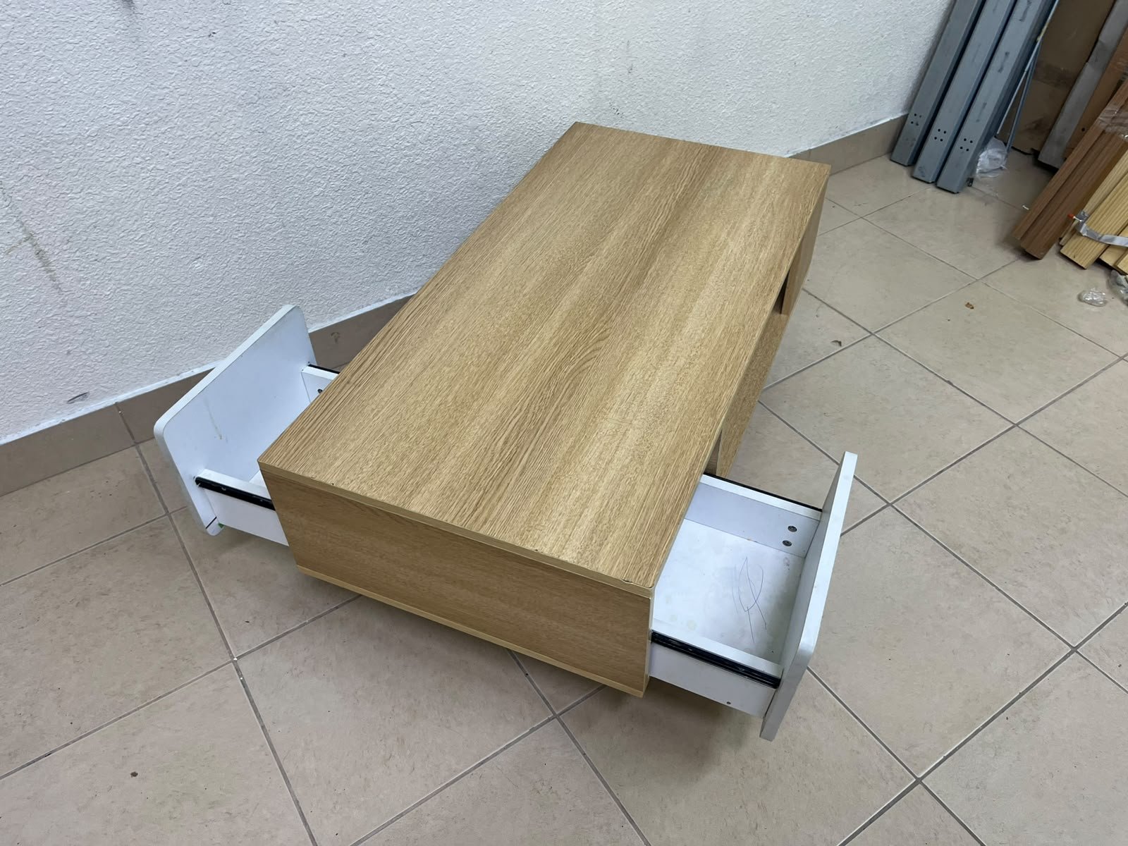 The Adonia coffee table by Danube Home is crafted from oak wood and features a rectangular top with a wood finish, accented by a distinctive white cabinet door. - Image 9