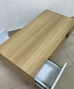 The Adonia coffee table by Danube Home is crafted from oak wood and features a rectangular top with a wood finish, accented by a distinctive white cabinet door. - Image 8