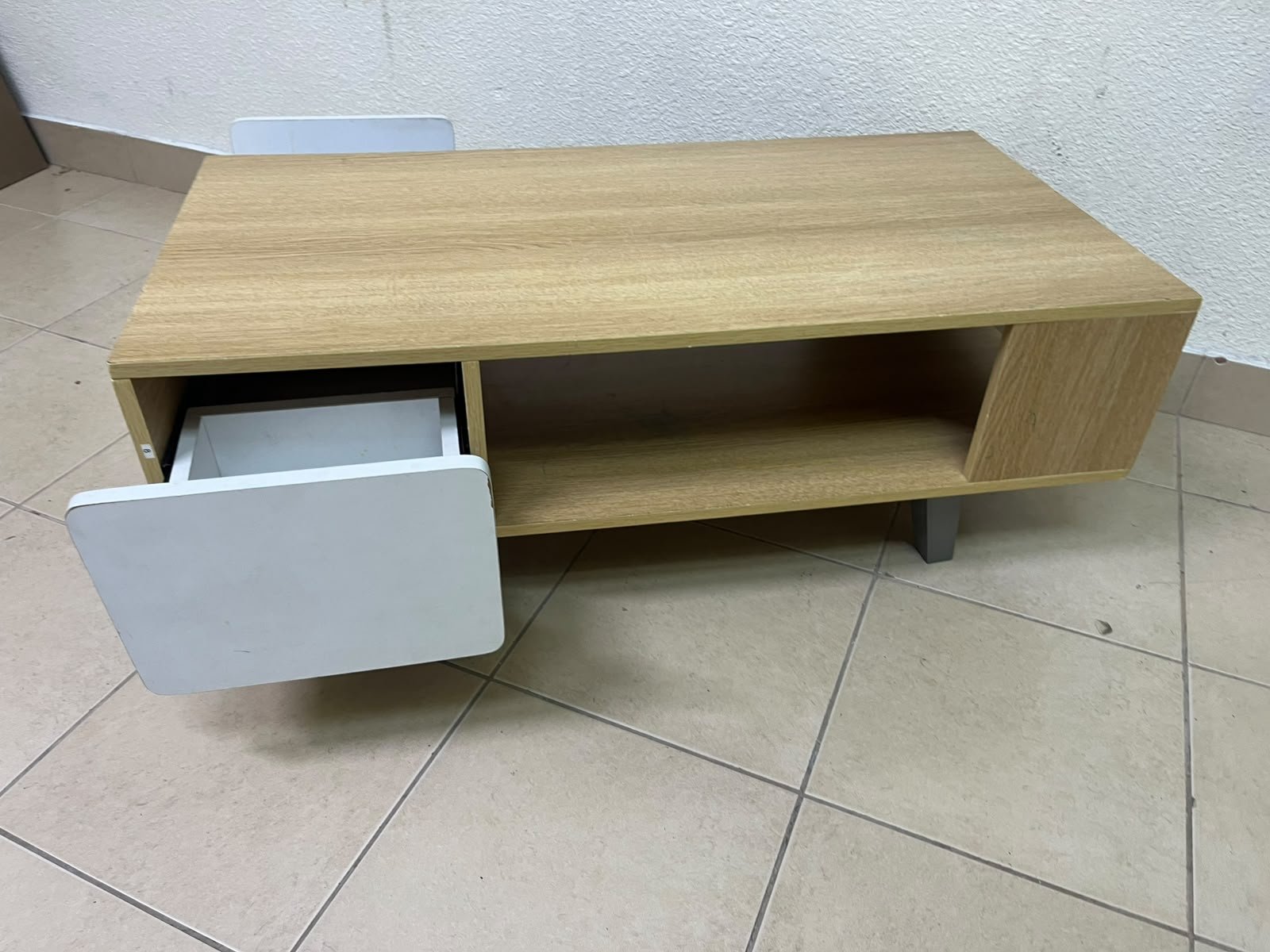 The Adonia coffee table by Danube Home is crafted from oak wood and features a rectangular top with a wood finish, accented by a distinctive white cabinet door. - Image 7