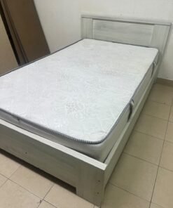 A double bed with a light wood finish, featuring a paneled headboard and a standard upholstered mattress. - Image 9