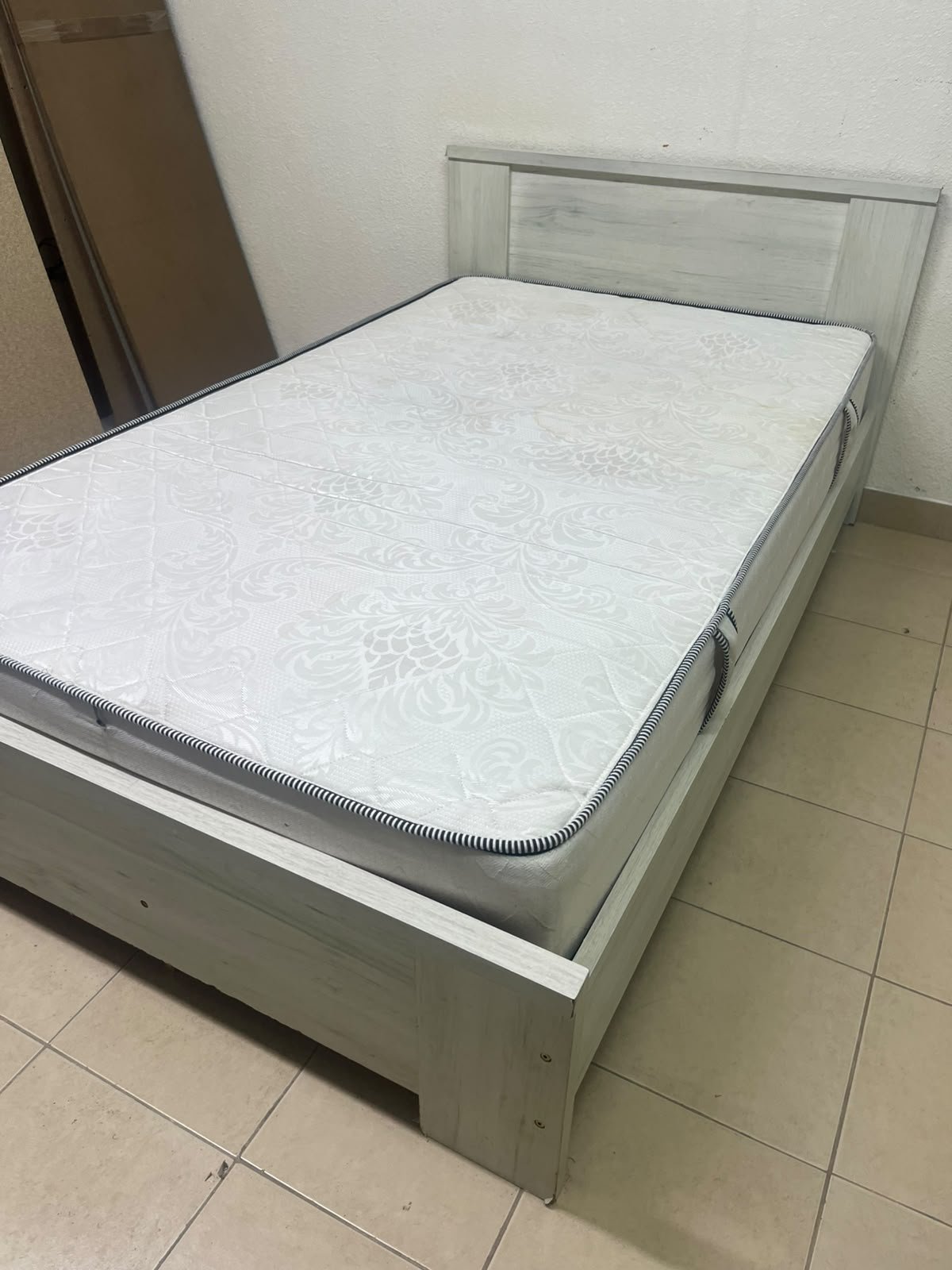 A double bed with a light wood finish, featuring a paneled headboard and a standard upholstered mattress. - Image 9