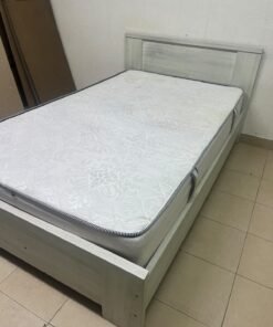 A double bed with a light wood finish, featuring a paneled headboard and a standard upholstered mattress. - Image 10