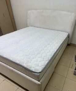 A modern, minimalist beige platform bed featuring a curved, upholstered headboard and a cushioned white mattress. - Image 2