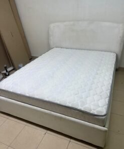 A modern, minimalist beige platform bed featuring a curved, upholstered headboard and a cushioned white mattress. - Image 5