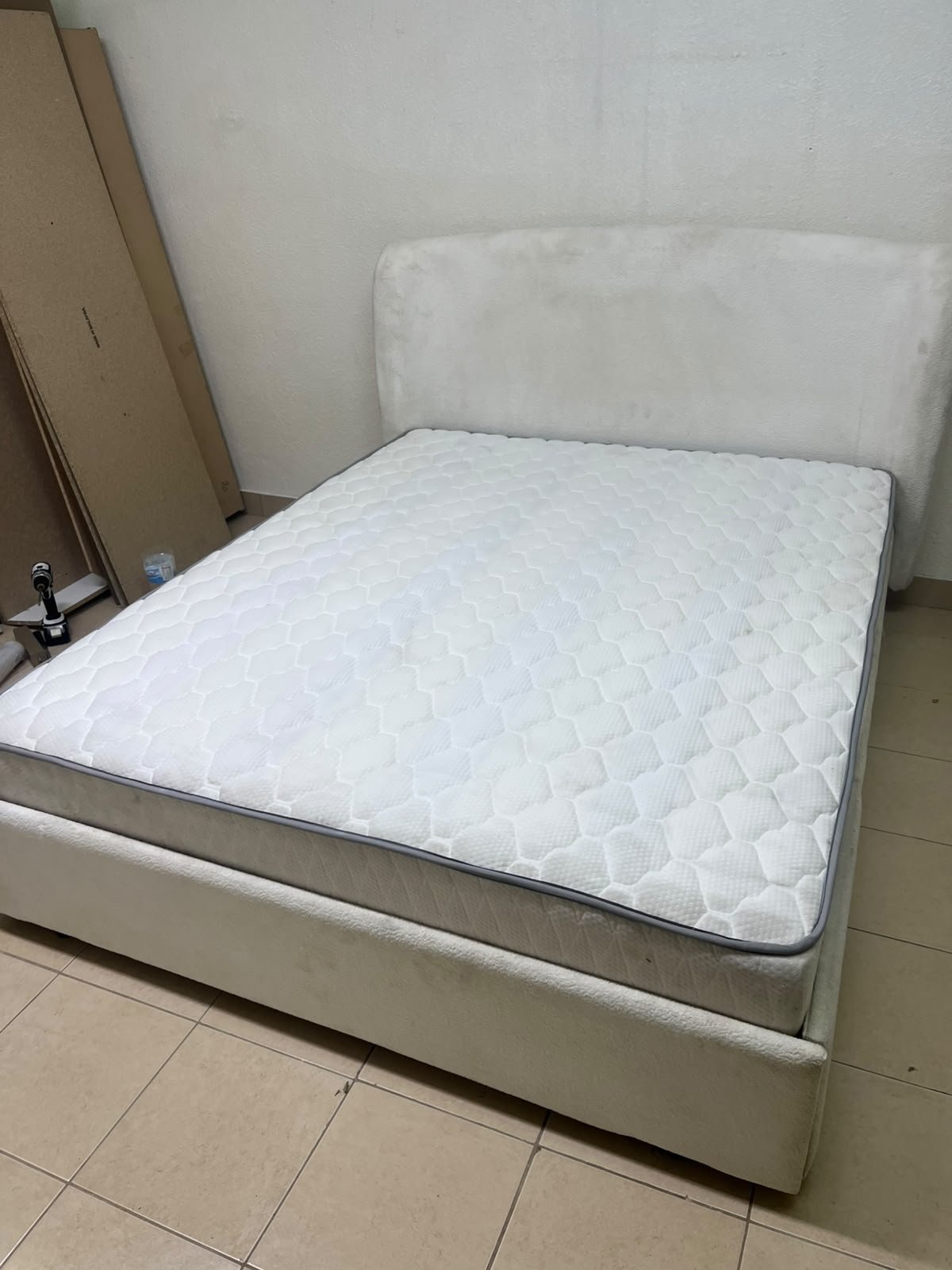 A modern, minimalist beige platform bed featuring a curved, upholstered headboard and a cushioned white mattress. - Image 5