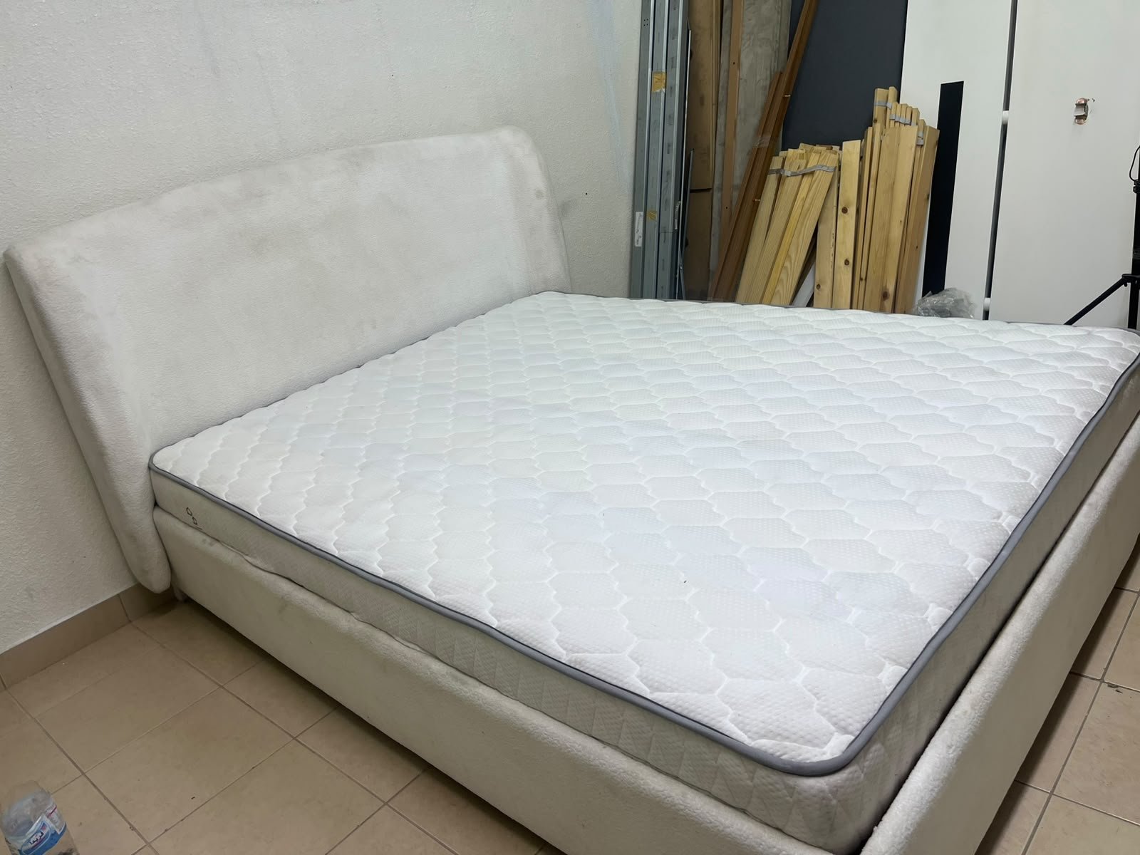A modern, minimalist beige platform bed featuring a curved, upholstered headboard and a cushioned white mattress. - Image 6