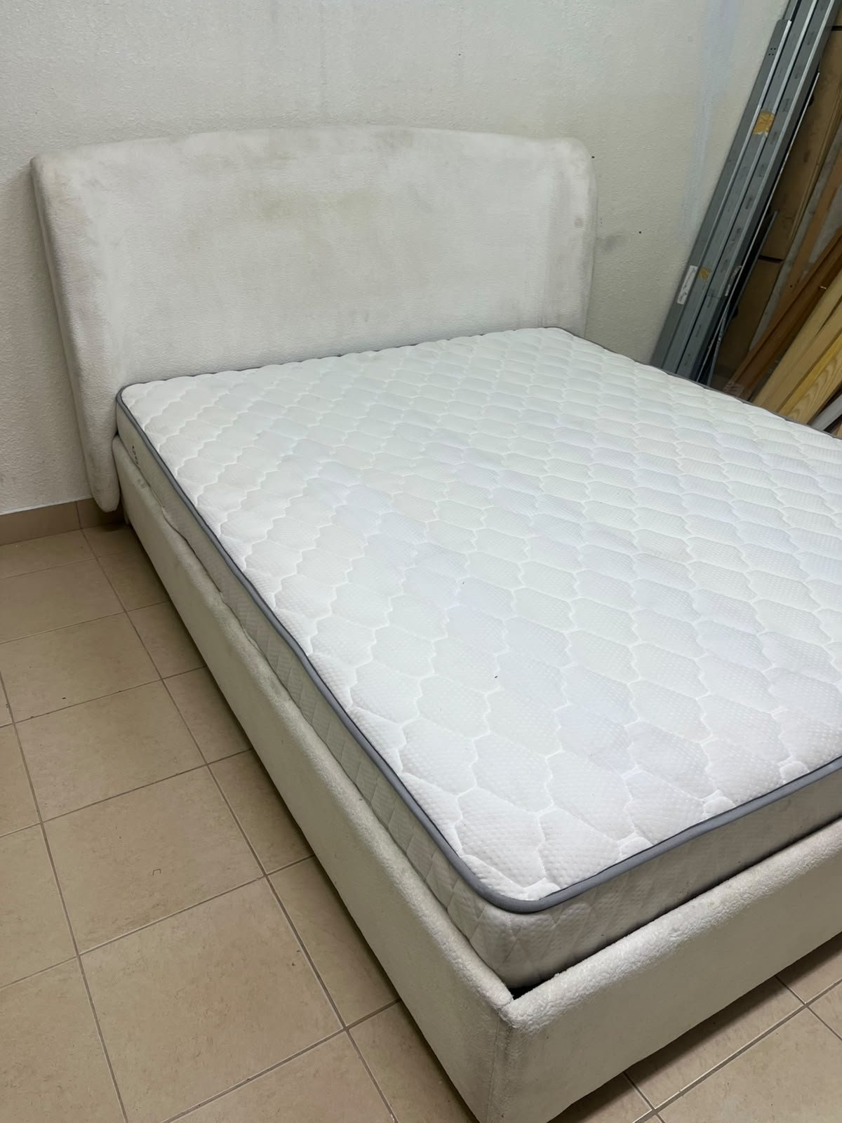 A modern, minimalist beige platform bed featuring a curved, upholstered headboard and a cushioned white mattress. - Image 7