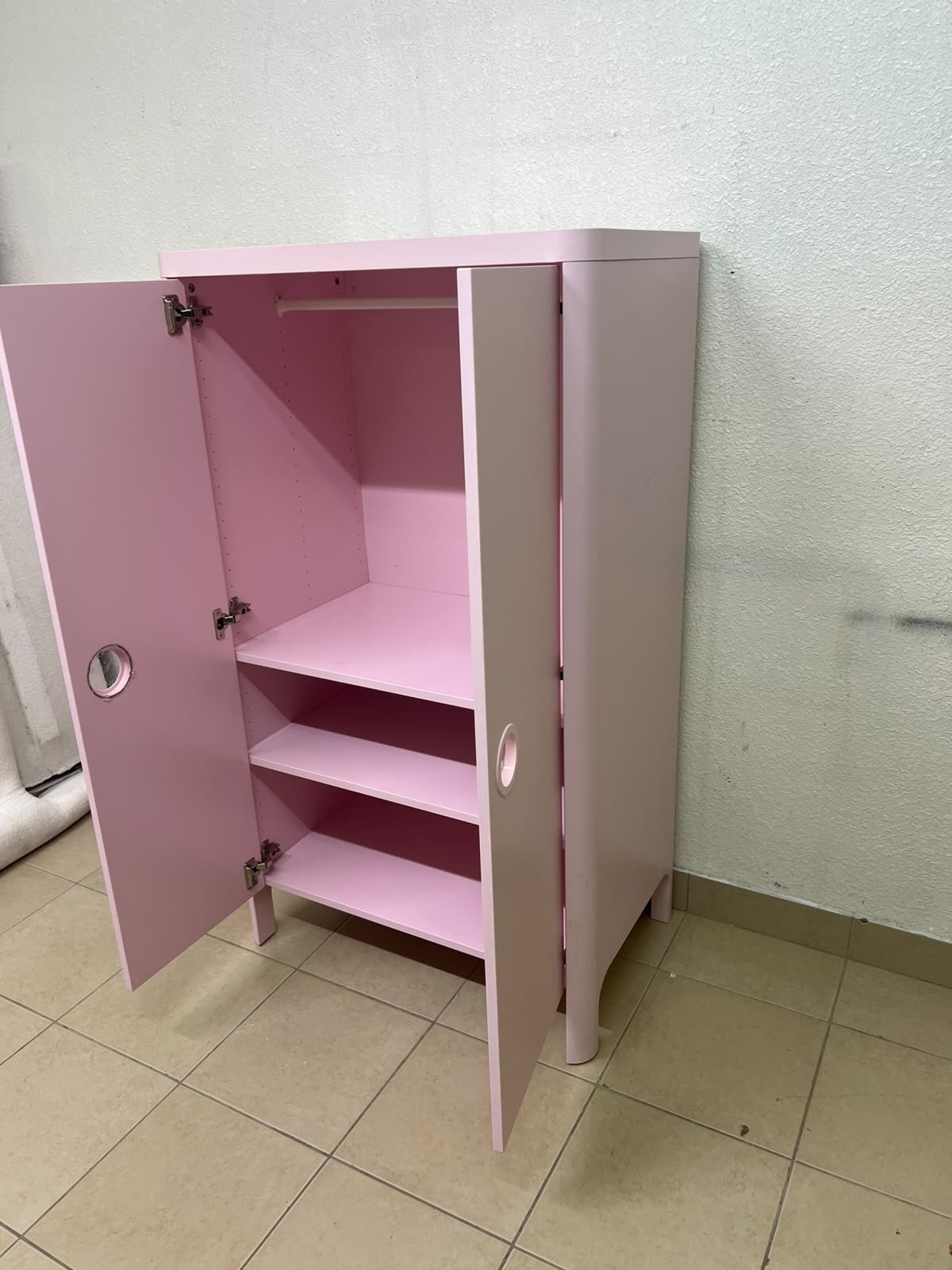 The "Busunge" children's wardrobe from IKEA comes in light pink and features rounded corners and distinctive circular cutouts that serve as handles. - Image 2