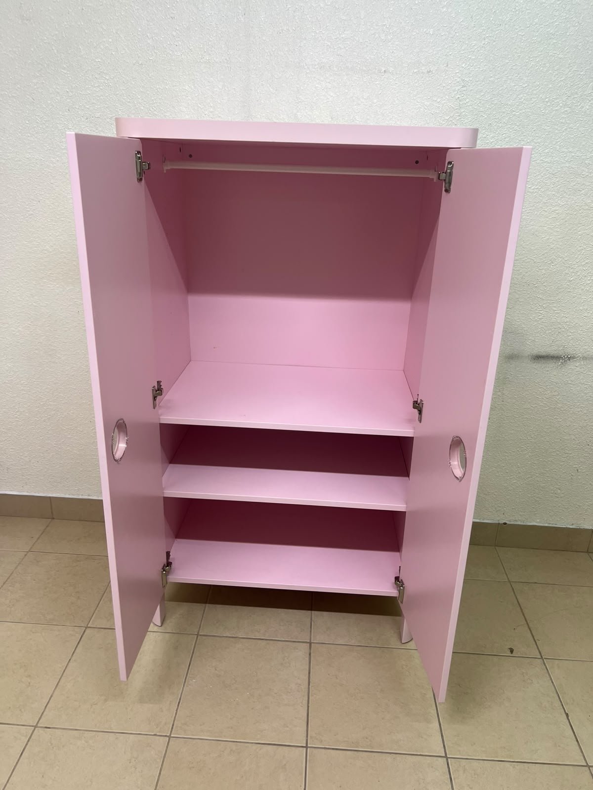 The "Busunge" children's wardrobe from IKEA comes in light pink and features rounded corners and distinctive circular cutouts that serve as handles. - Image 3