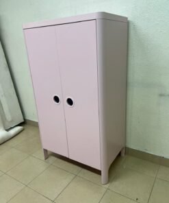 The "Busunge" children's wardrobe from IKEA comes in light pink and features rounded corners and distinctive circular cutouts that serve as handles.