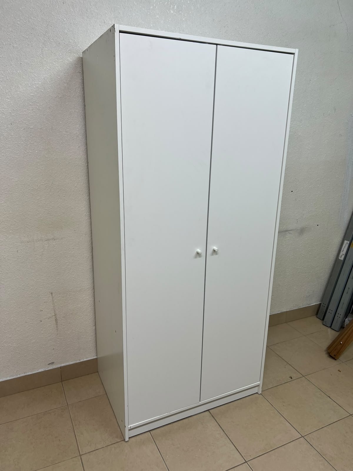 The IKEA KLEPPSTAD white two-door wardrobe features a simple design with two round handles and dimensions of 79x55x176 cm.