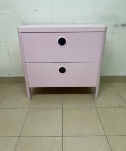 The "Busunge" chest of drawers from IKEA comes in light pink and features distinctive, circular cut-out handles.