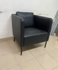 The IKEA EKERÖ armchair, upholstered in black Bomstad material, featuring distinctive slender black legs and a loose back cushion. - Image 2