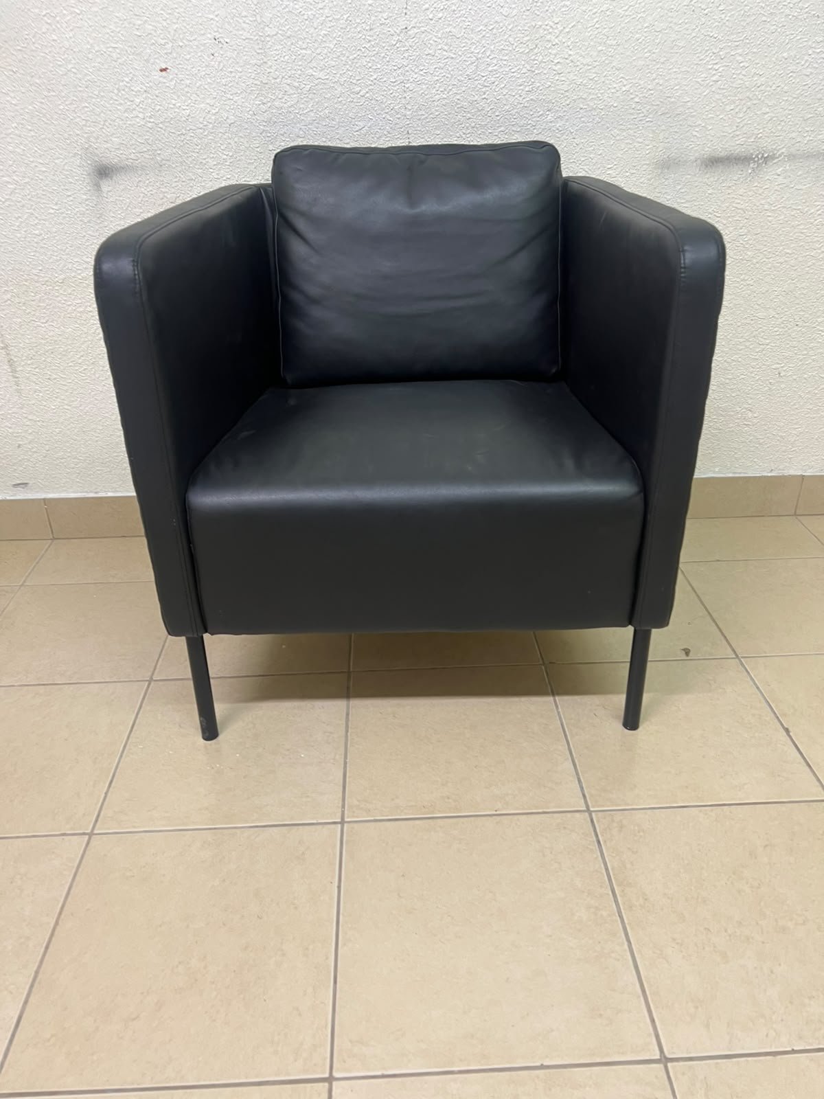 The IKEA EKERÖ armchair, upholstered in black Bomstad material, featuring distinctive slender black legs and a loose back cushion. - Image 3