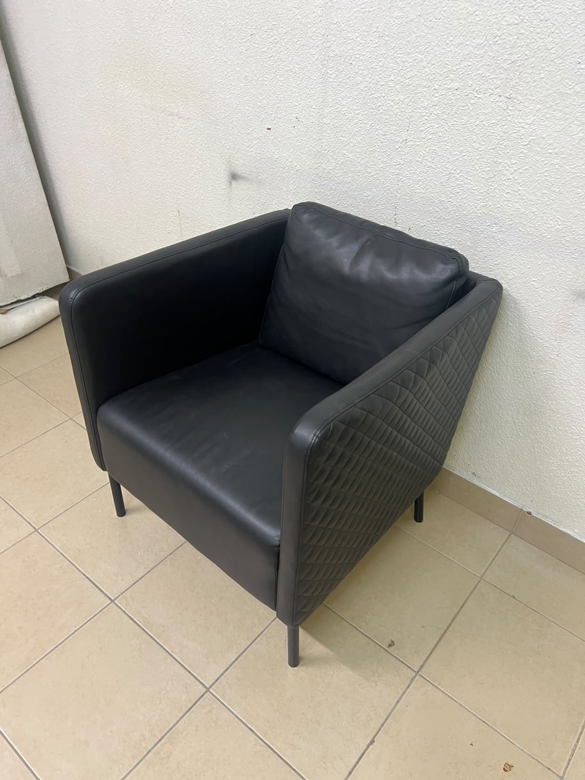 The IKEA EKERÖ armchair, upholstered in black Bomstad material, featuring distinctive slender black legs and a loose back cushion. - Image 4