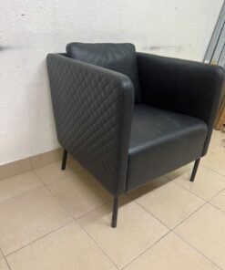 The IKEA EKERÖ armchair, upholstered in black Bomstad material, featuring distinctive slender black legs and a loose back cushion. - Image 5
