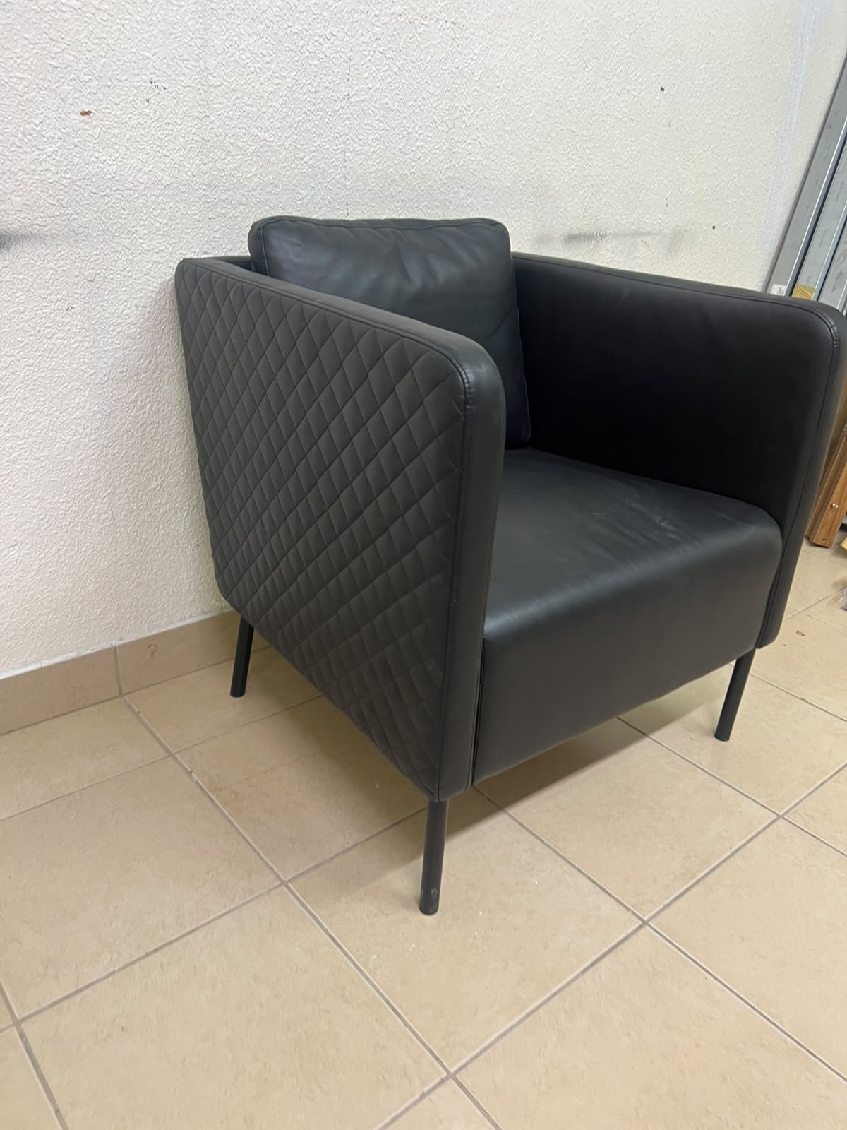 The IKEA EKERÖ armchair, upholstered in black Bomstad material, featuring distinctive slender black legs and a loose back cushion. - Image 5