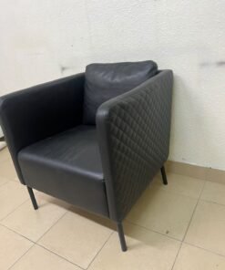The IKEA EKERÖ armchair, upholstered in black Bomstad material, featuring distinctive slender black legs and a loose back cushion. - Image 8