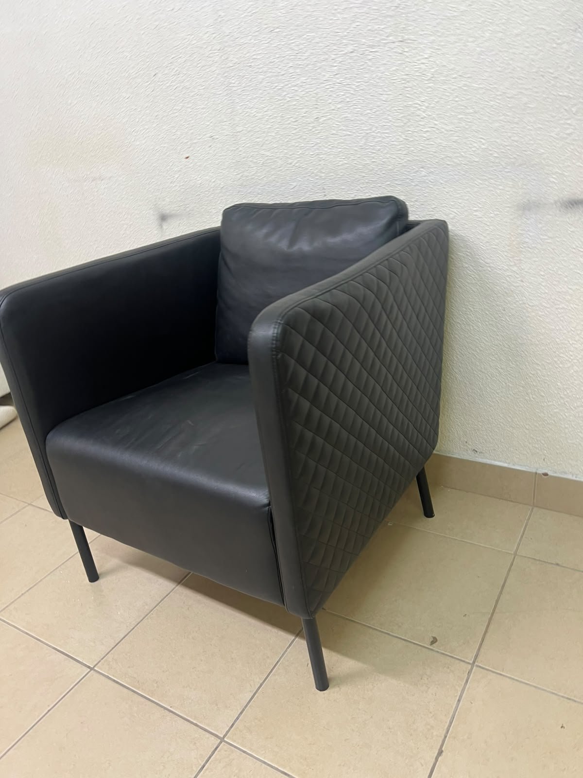 The IKEA EKERÖ armchair, upholstered in black Bomstad material, featuring distinctive slender black legs and a loose back cushion. - Image 8