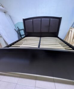 This dark wood platform bed features an arched, paneled headboard upholstered in faux leather, along with distinctive cylindrical corner legs accented with metallic silver-tone details. - Image 2