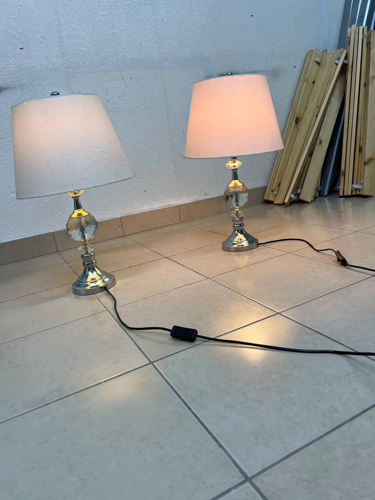 A pair of table lamps featuring chrome finishes and crystal-ball details, distinguished by classic cylindrical fabric shades.