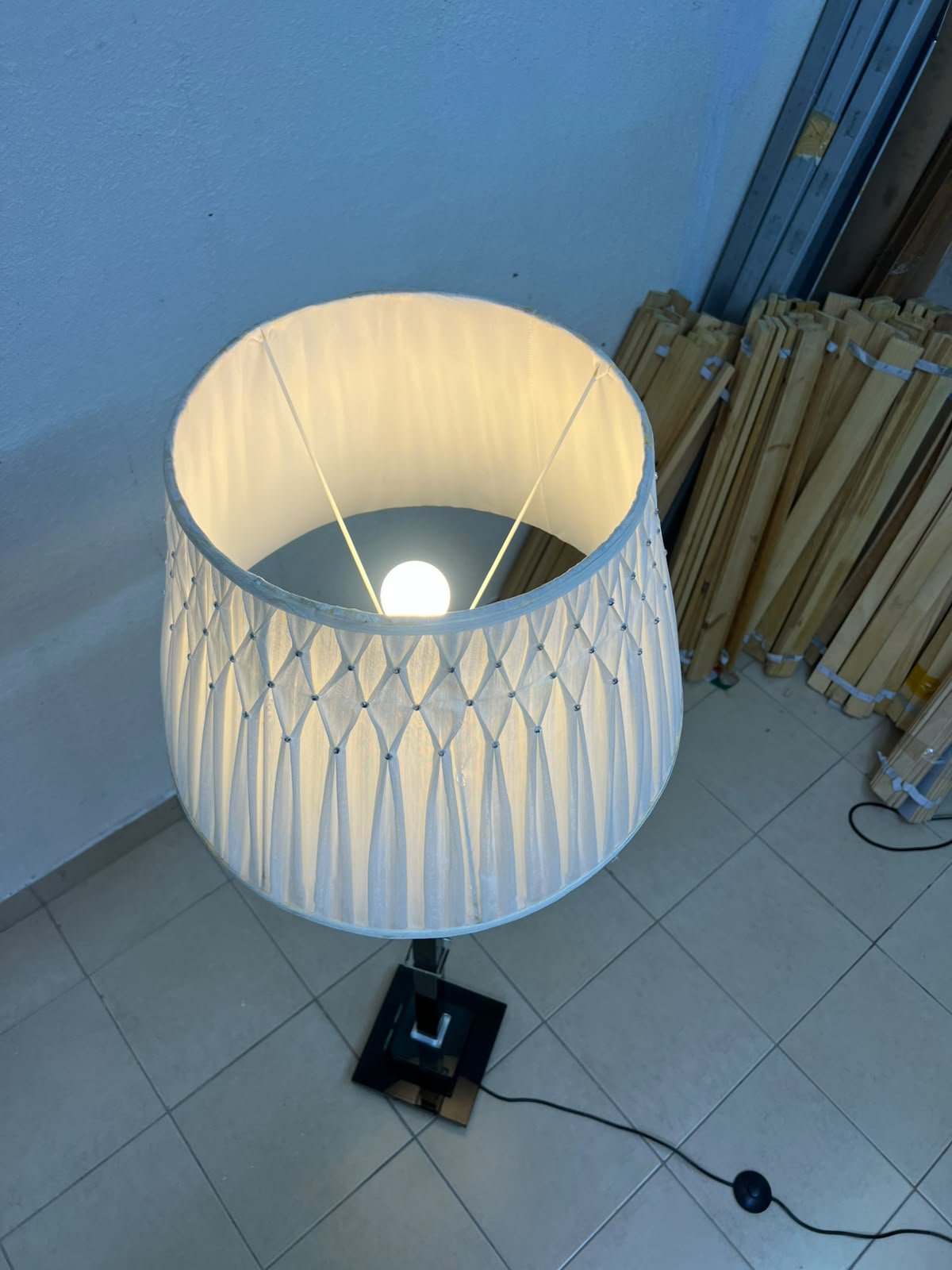 An elegant floor lamp combining crystal and black metal, featuring a conical, pleated fabric shade and a multi-faceted glass element positioned near the top of the lamp's stem. - Image 10