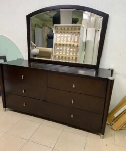 A dark wood double dresser with six drawers and a matching arched horizontal mirror, featuring a curved top frame and silver-colored metal handles.