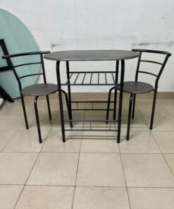 Two chairs and a table featuring an oval grey tabletop, a black tubular steel frame, and built-in storage shelves.