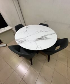 This modern dining set features a round table with a white marble-effect top, paired with curved, arm-equipped chairs upholstered in dark gray and supported by black metal legs. - Image 2