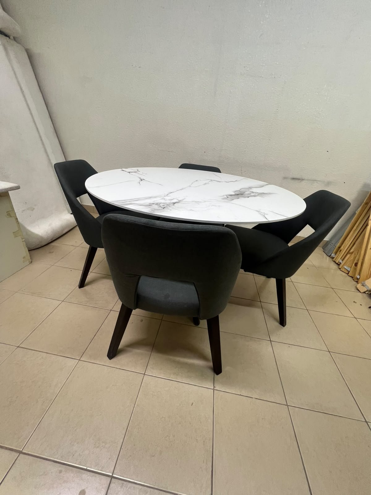 This modern dining set features a round table with a white marble-effect top, paired with curved, arm-equipped chairs upholstered in dark gray and supported by black metal legs. - Image 6