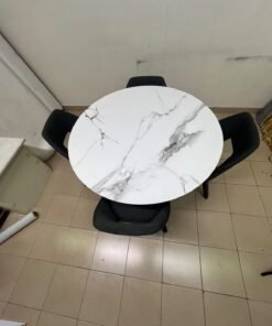 This modern dining set features a round table with a white marble-effect top, paired with curved, arm-equipped chairs upholstered in dark gray and supported by black metal legs. - Image 7
