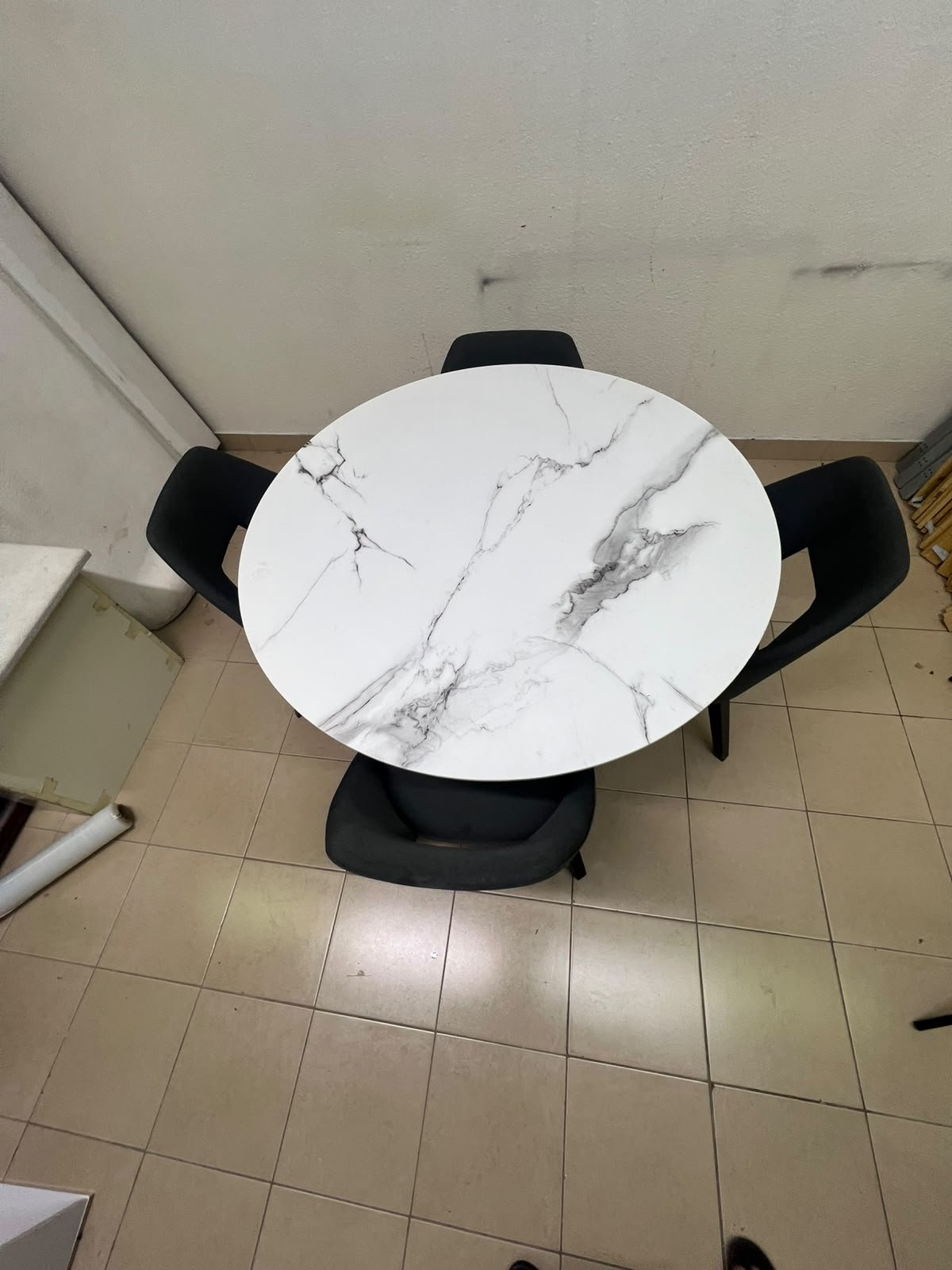 This modern dining set features a round table with a white marble-effect top, paired with curved, arm-equipped chairs upholstered in dark gray and supported by black metal legs. - Image 7