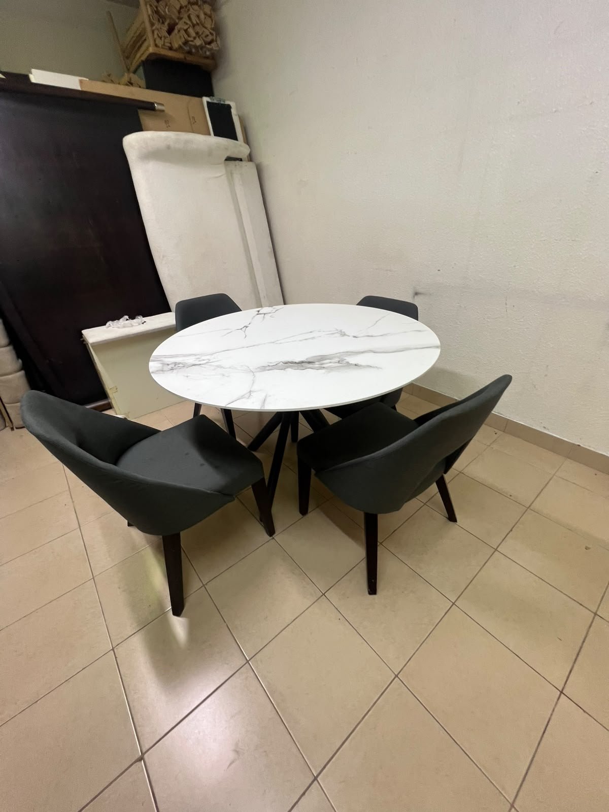 This modern dining set features a round table with a white marble-effect top, paired with curved, arm-equipped chairs upholstered in dark gray and supported by black metal legs. - Image 8