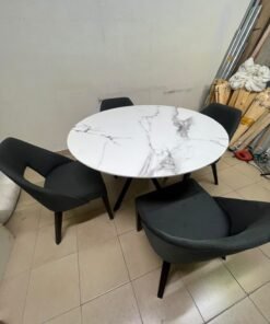 This modern dining set features a round table with a white marble-effect top, paired with curved, arm-equipped chairs upholstered in dark gray and supported by black metal legs. - Image 9