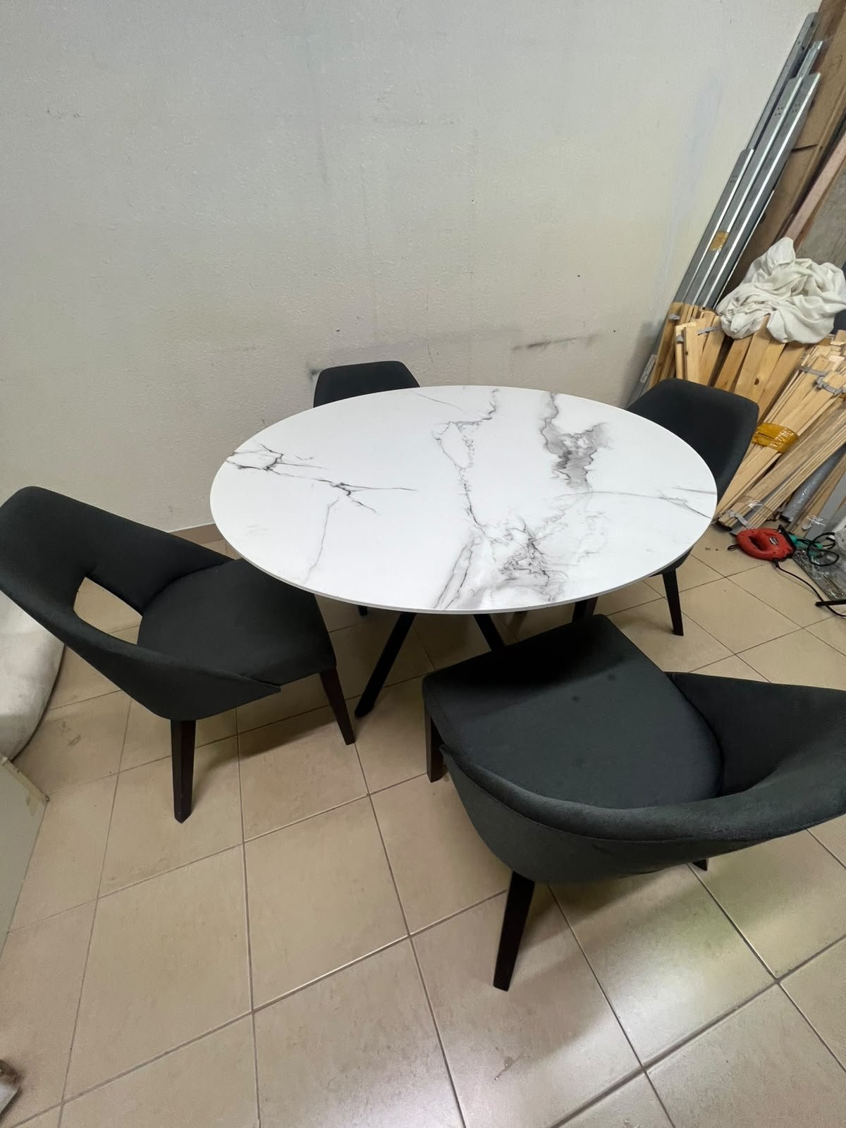 This modern dining set features a round table with a white marble-effect top, paired with curved, arm-equipped chairs upholstered in dark gray and supported by black metal legs. - Image 9