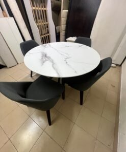 This modern dining set features a round table with a white marble-effect top, paired with curved, arm-equipped chairs upholstered in dark gray and supported by black metal legs. - Image 11