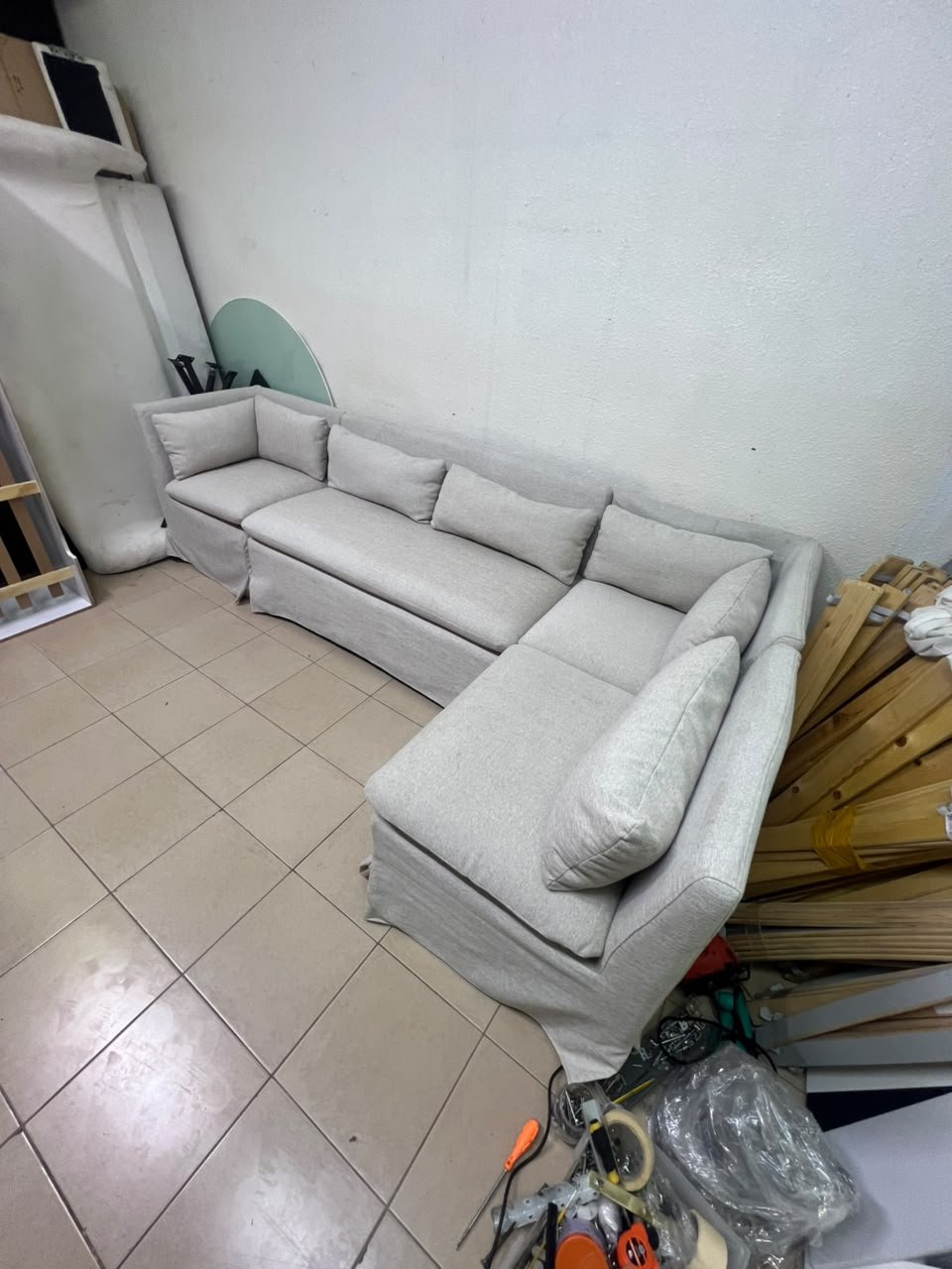 The L-shaped sectional sofa features a removable cover; it is the Crate & Barrel Belmar Modular Seating model, upholstered in a light gray, high-performance fabric with a linen-like texture, and includes comfortable back and arm cushions. - Image 7