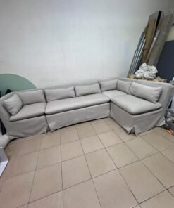 The L-shaped sectional sofa features a removable cover; it is the Crate & Barrel Belmar Modular Seating model, upholstered in a light gray, high-performance fabric with a linen-like texture, and includes comfortable back and arm cushions. - Image 9