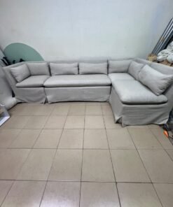The L-shaped sectional sofa features a removable cover; it is the Crate & Barrel Belmar Modular Seating model, upholstered in a light gray, high-performance fabric with a linen-like texture, and includes comfortable back and arm cushions. - Image 11
