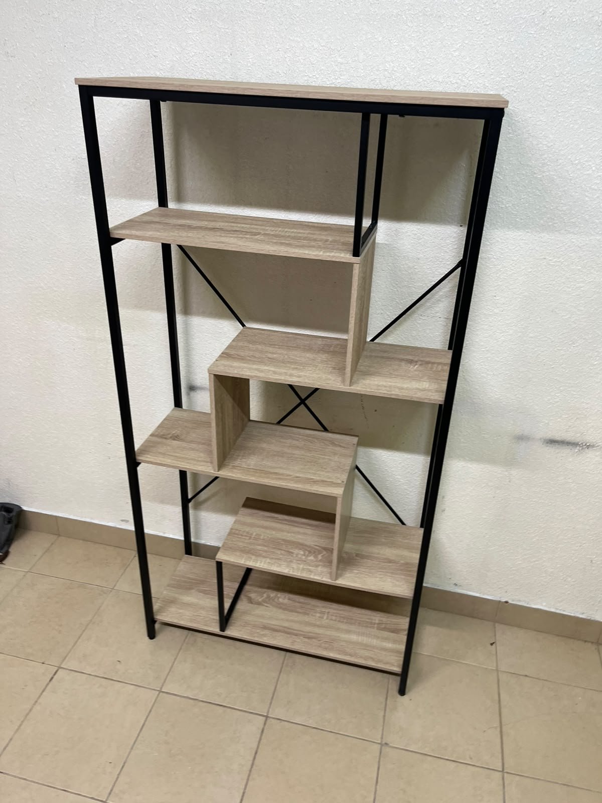 A shelving unit featuring a modern industrial design, consisting of a sturdy black metal frame and natural-look wooden shelves arranged in a tiered, graduated-width layout. - Image 3